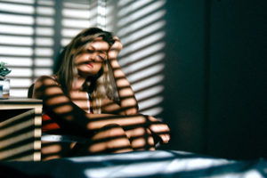 Fotoet viser en kvinde i sit hjem. Siden handler om at savne at være en del af fællesskabet.