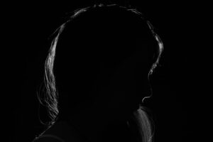 Fotoet viser en kvinde i mørke. Siden handler om "Når skammen ødelægger selvværdet". Fotoet er taget af Kevin Jesus Horacio.